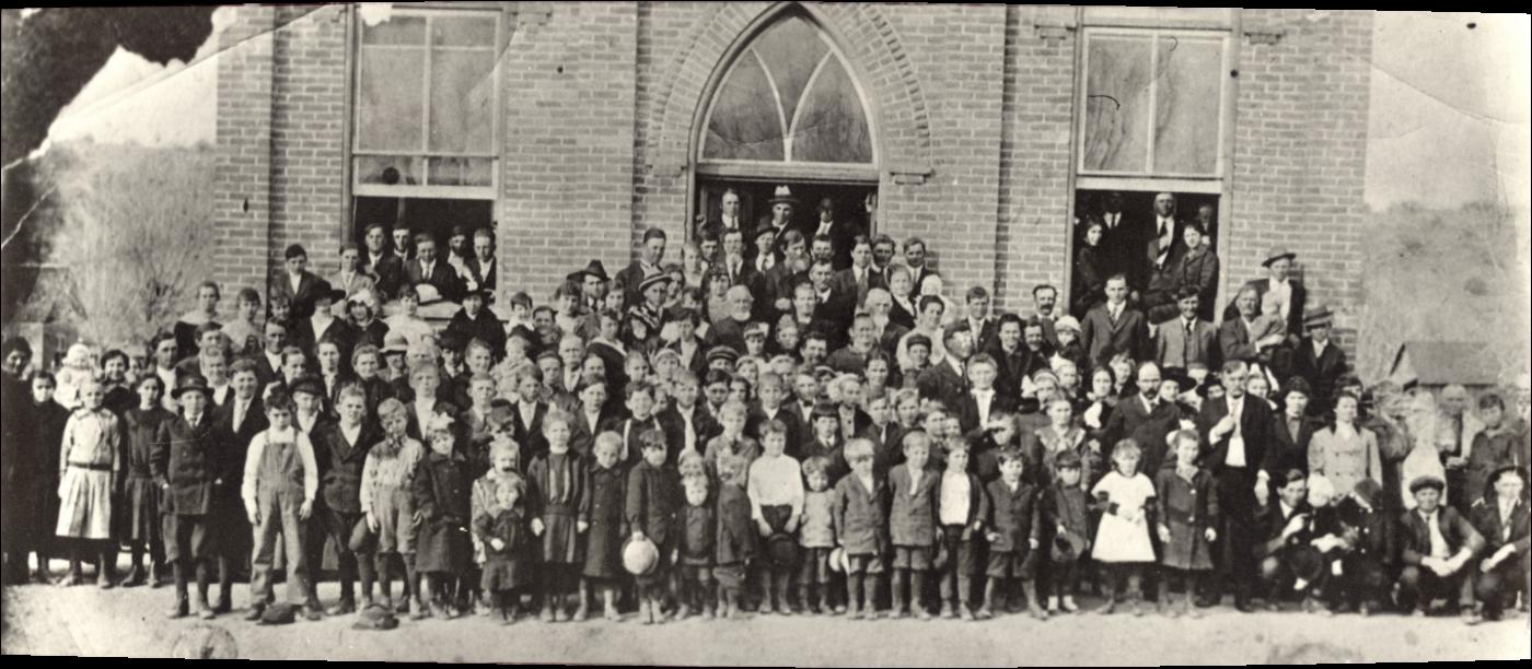 Large group of people in front of a brick building