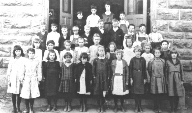 Teacher and students in front of the Woodward School
