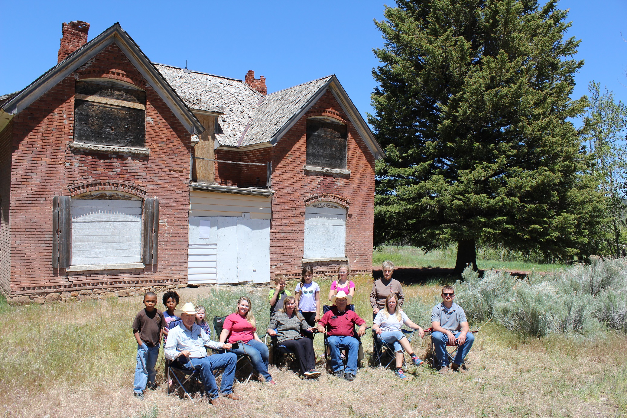 Front of the Page Ranch house with Page family descendants sitting in front