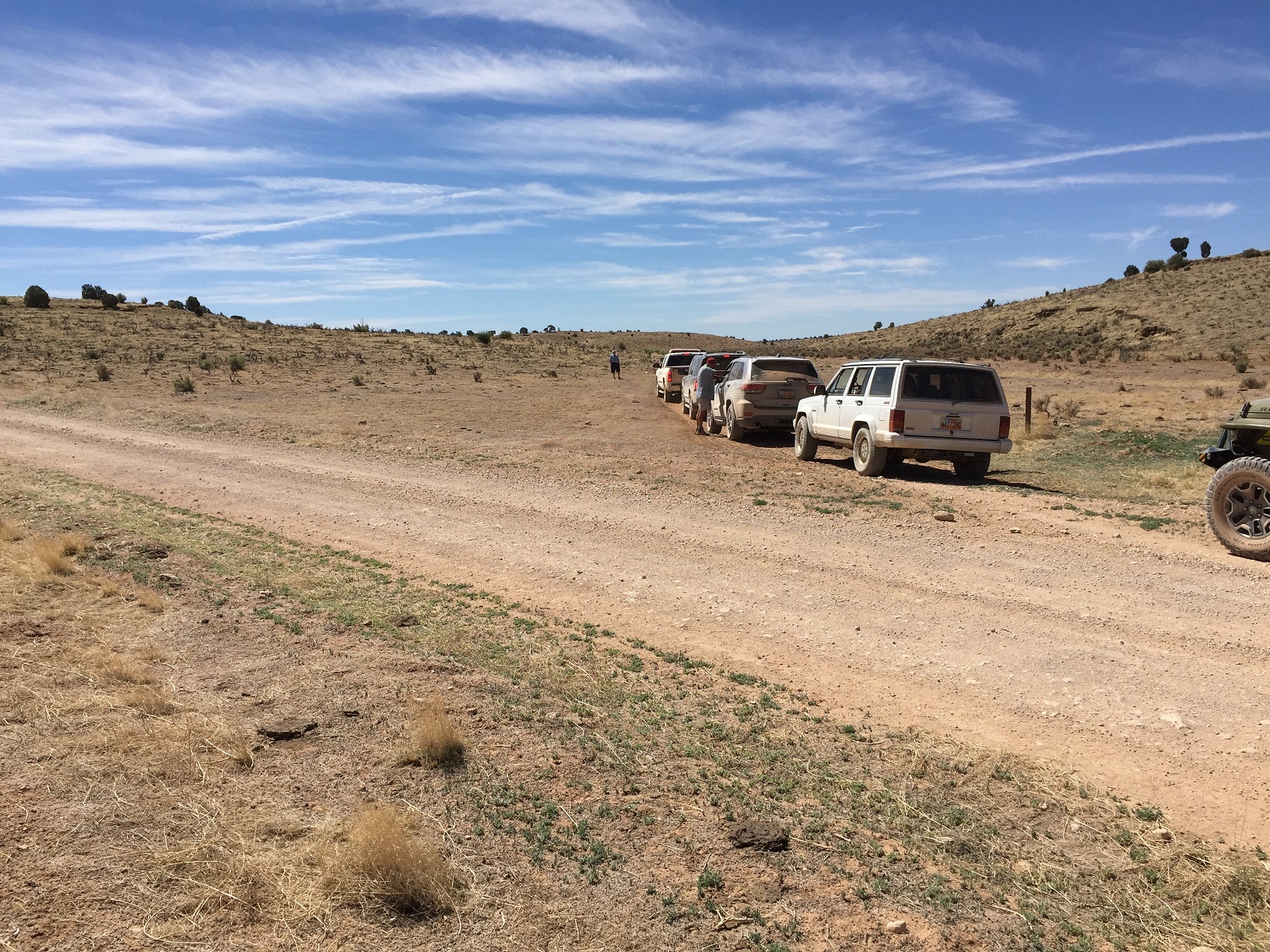A caravan of cars turning from an unmarked road onto BLM Road 1058 on the Arizona Strip