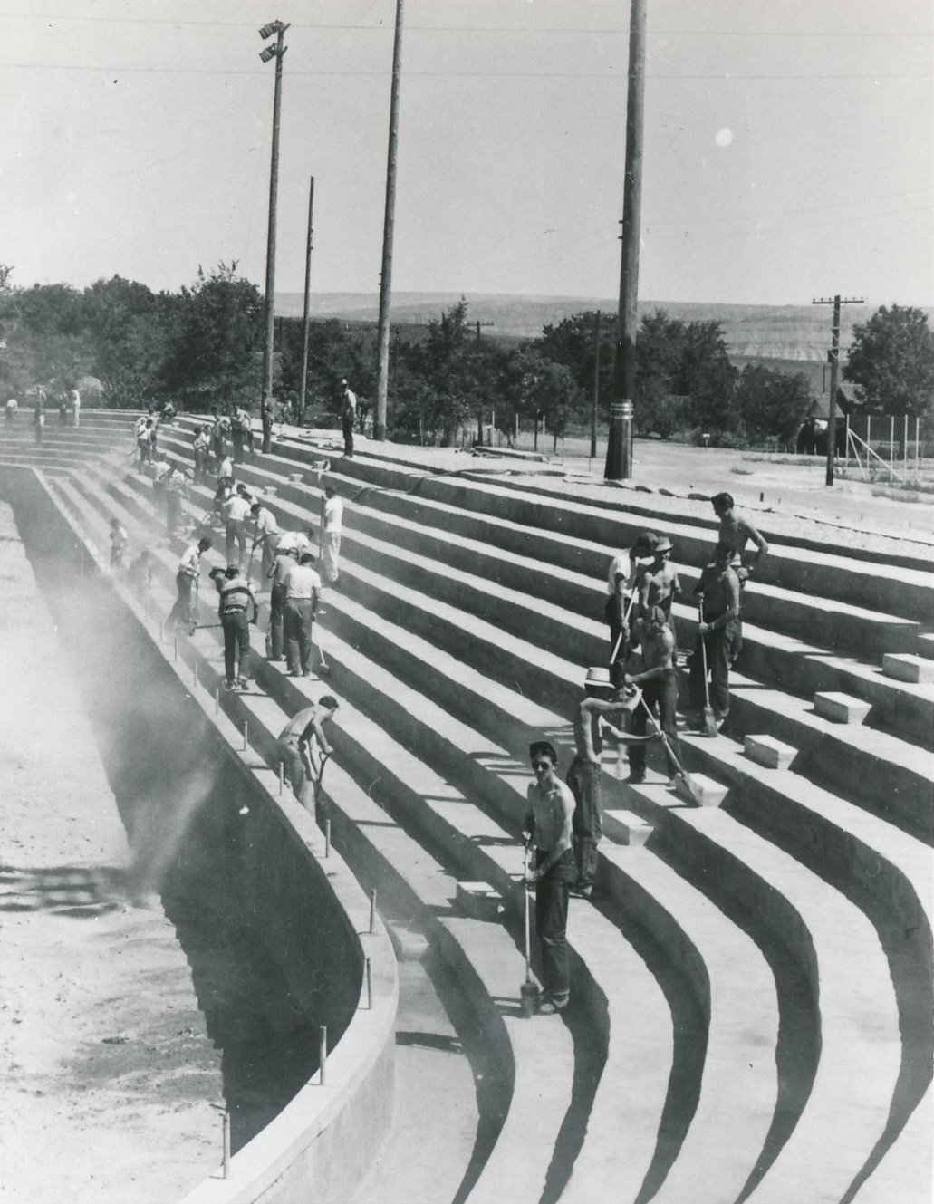 Workers finishing the cement benches along the south side of the Dixie Sun Bowl