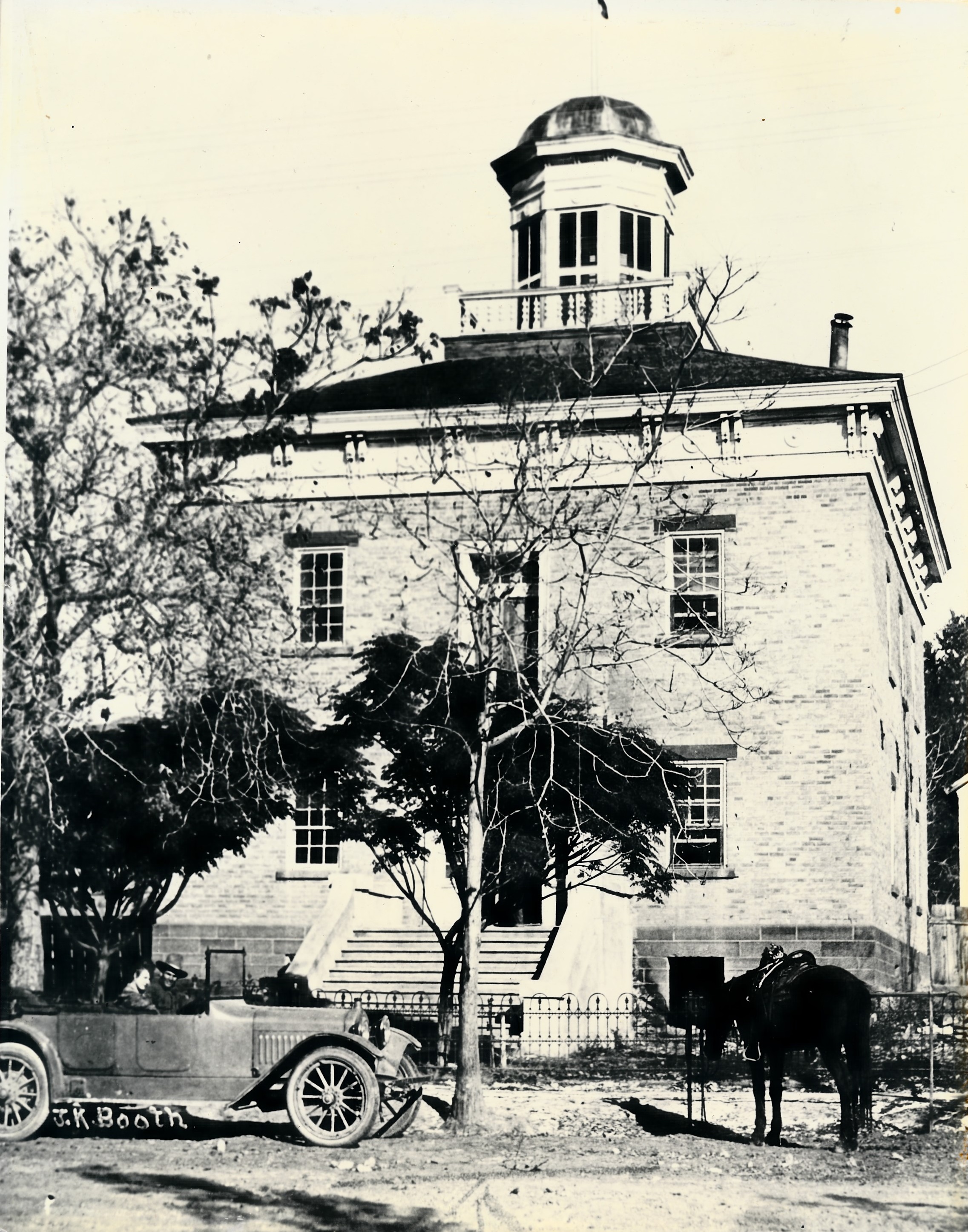 A car and horse in front of the old Washington County Courthouse