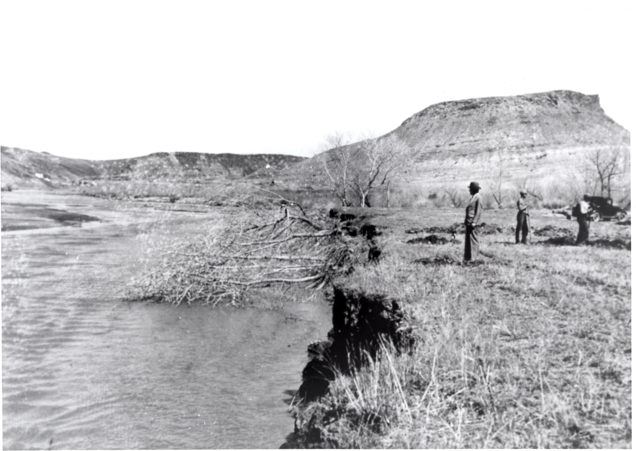 Some men on the eroding Virgen River bank with Shinob Kibe in the background