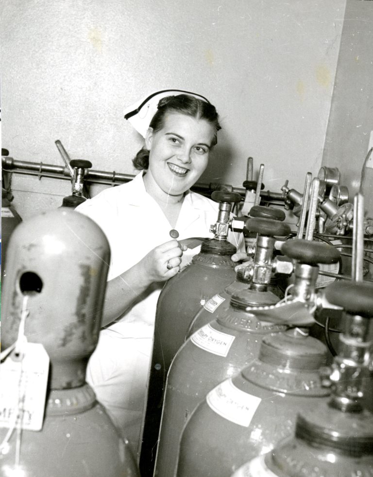Nurse and gas storage tanks at the Dixie Pioneer Memorial Hospital
