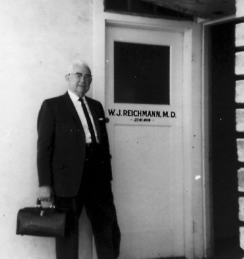 Dr. Wilford J. Reichmann outside the door to his office