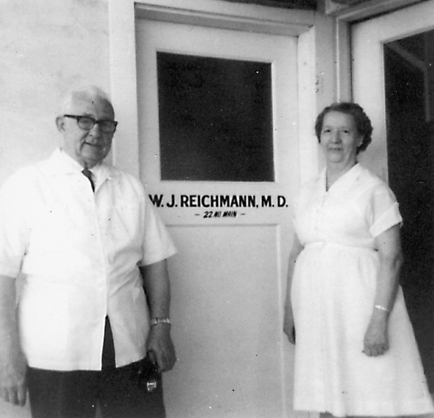 Dr. Reichmann and his nurse outside the door to his office