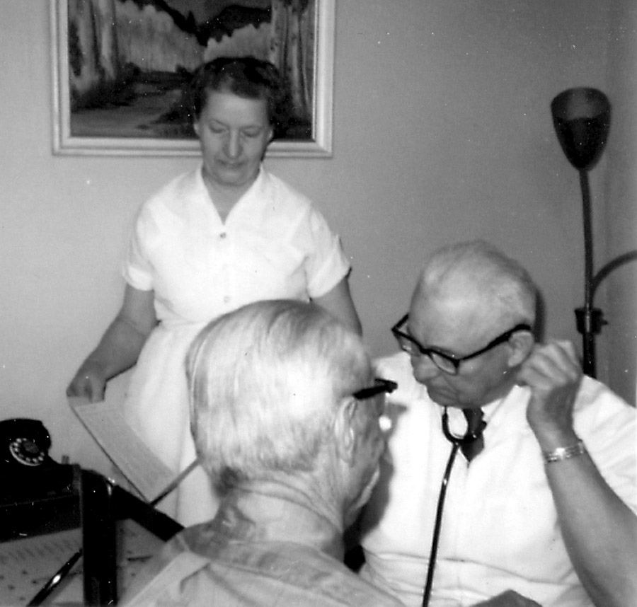 Dr. Reichmann examining a patient with his nurse standing by