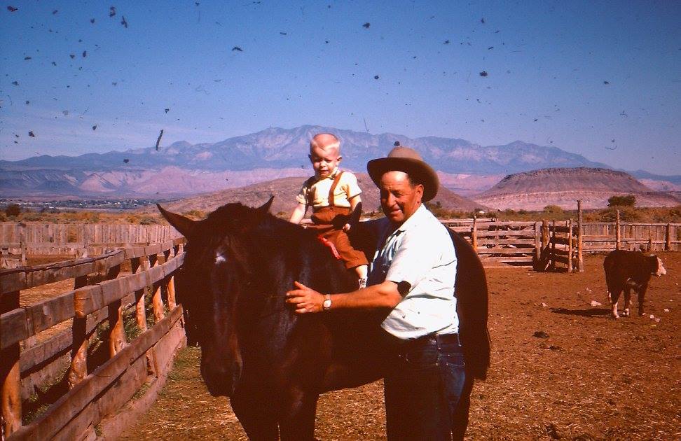 Iliff Andrus standing with his grandson, Mark Andrus, on a horse