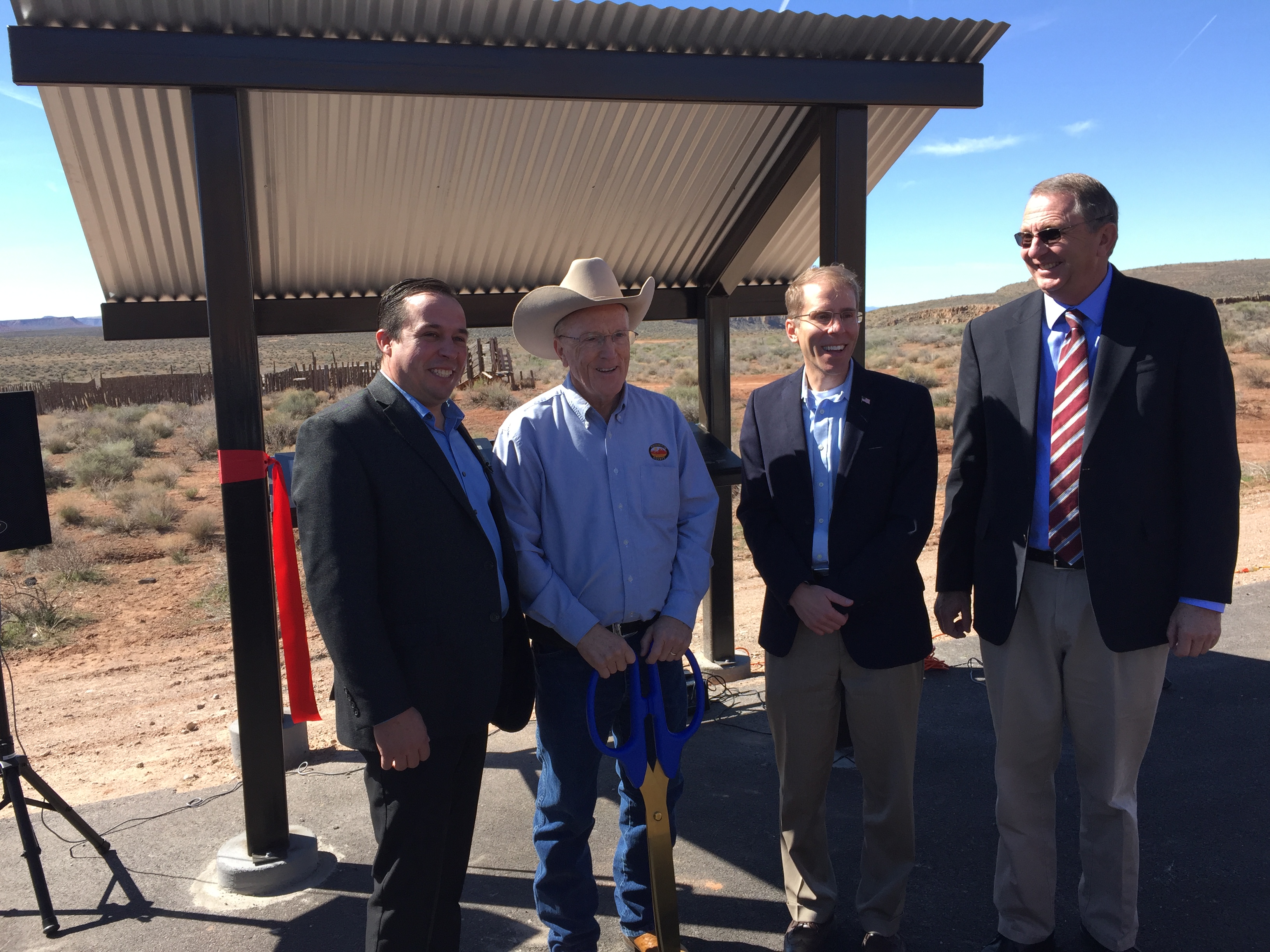 Four elected officials at the ribbon cutting ceremony of a new informational kiosk