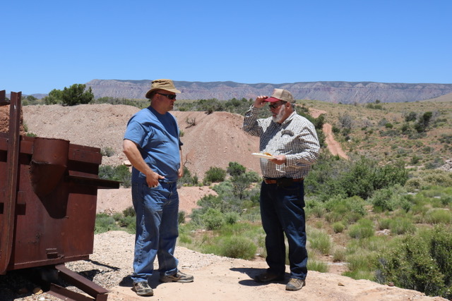 Two men talking by the old furnace at the Grand Gulch Mine