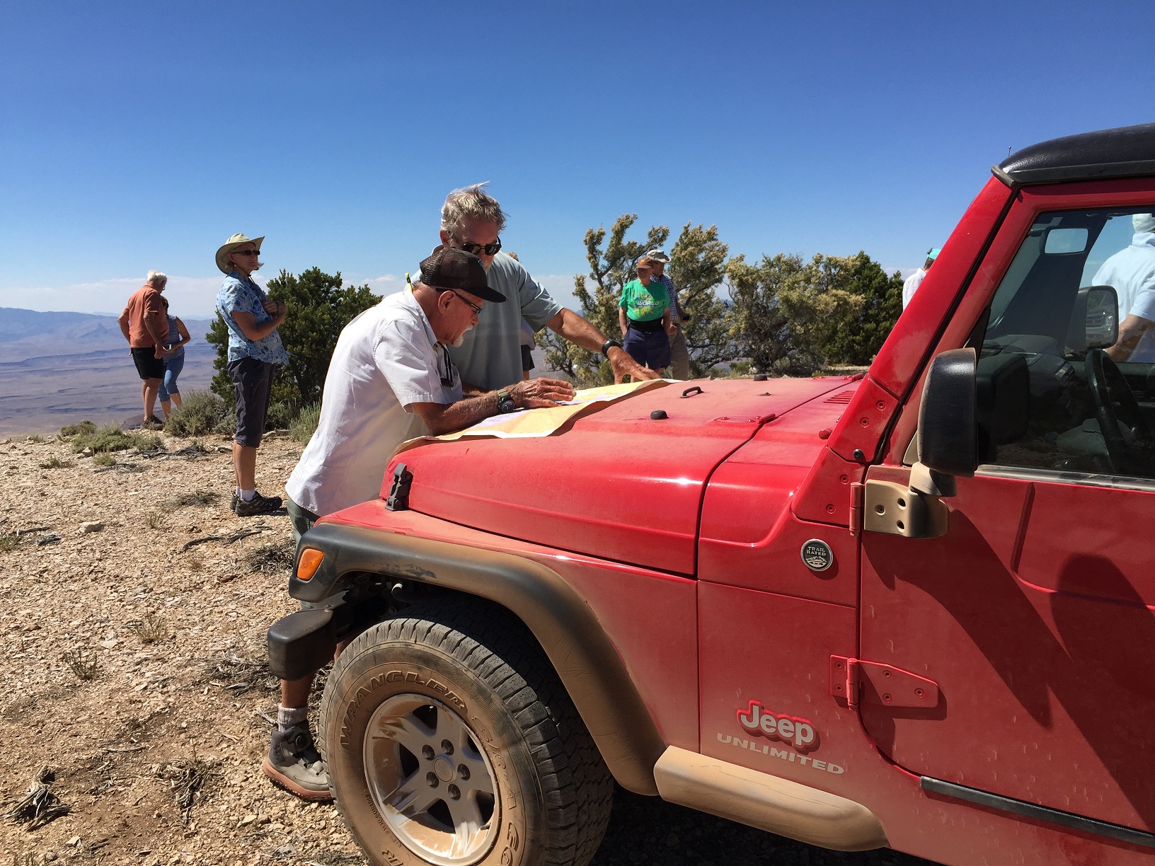 Milt Hokanson and ??? looking at a map on the hood of Milt's Jeep at Hudson Point