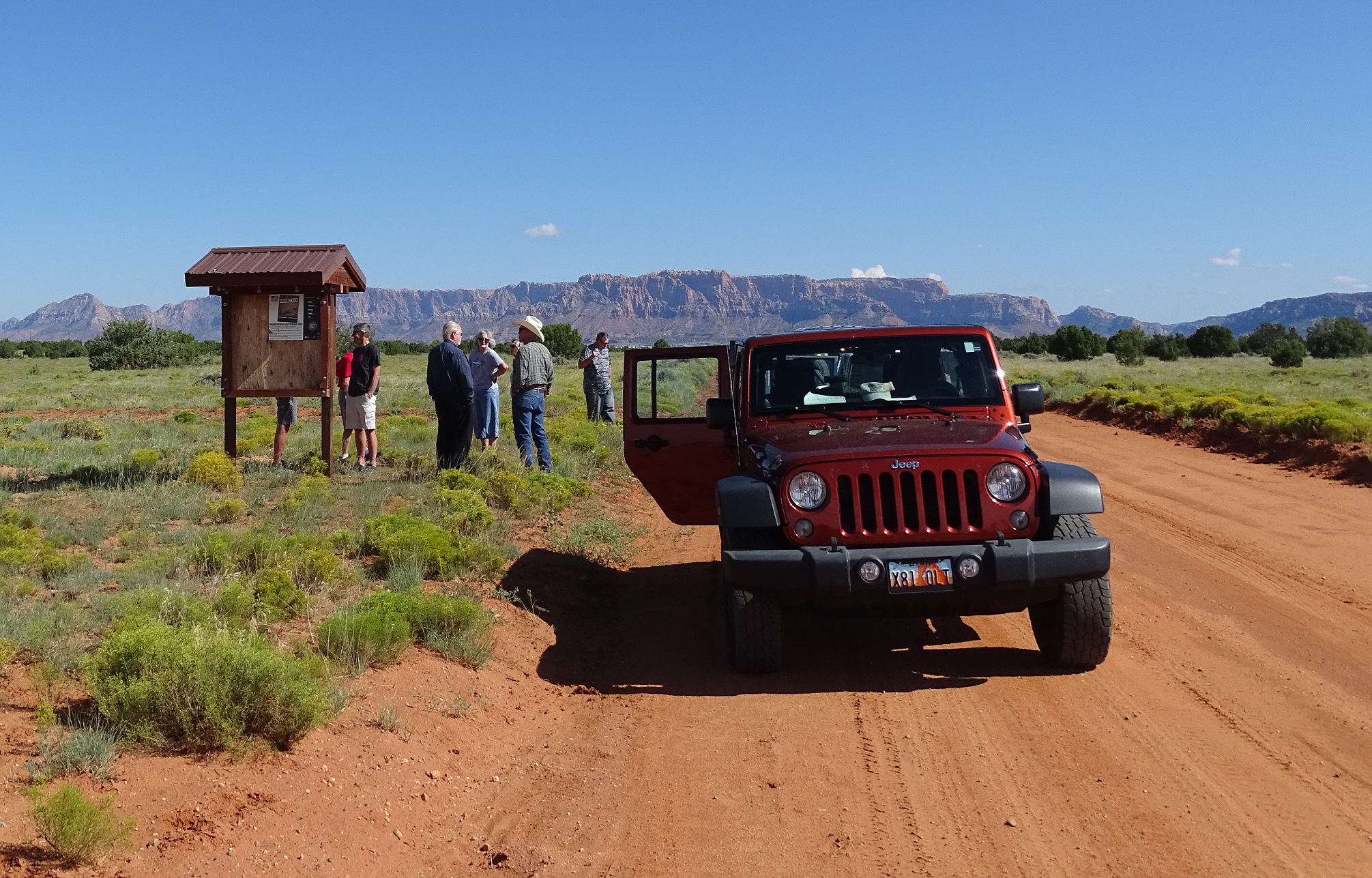 People gathered at a roadside sign on Mohave County Road 5