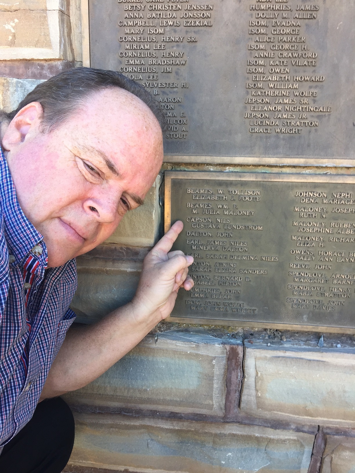 Fred Penney pointing out the names of his ancestors on a Virgin, Utah monument