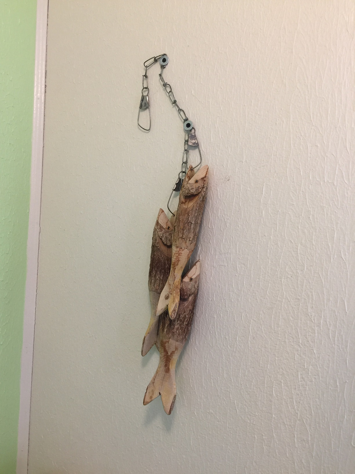 A string of fish carved in wood hanging in Cabin 1 at the Big Springs Rental Cabins