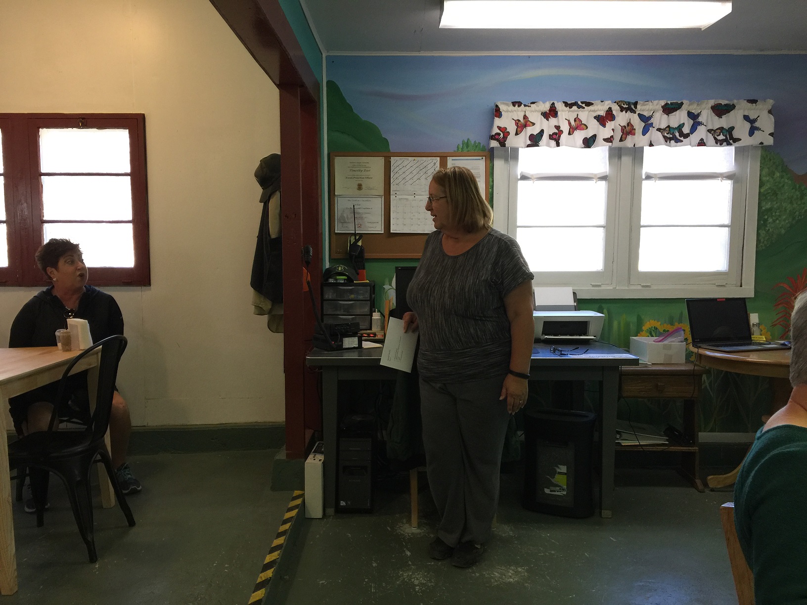 Cathey East speaking to DASIA field trip participants in the common area at the Big Springs Rental Cabins