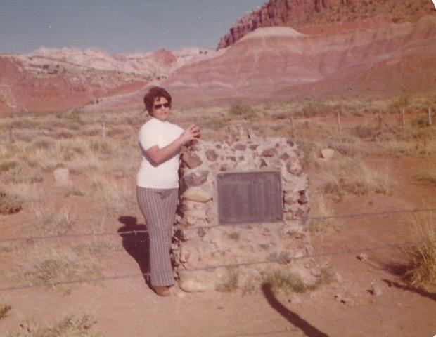 Betty Clegg standing by a monument in the Paria Cemetery