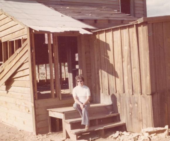 Betty Clegg sitting on the steps of a movie set building in the old ghost town of Paria, Utah