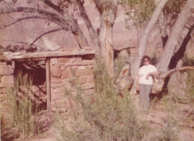Betty Clegg standing next to an old rock fort in the ghost town of Paria