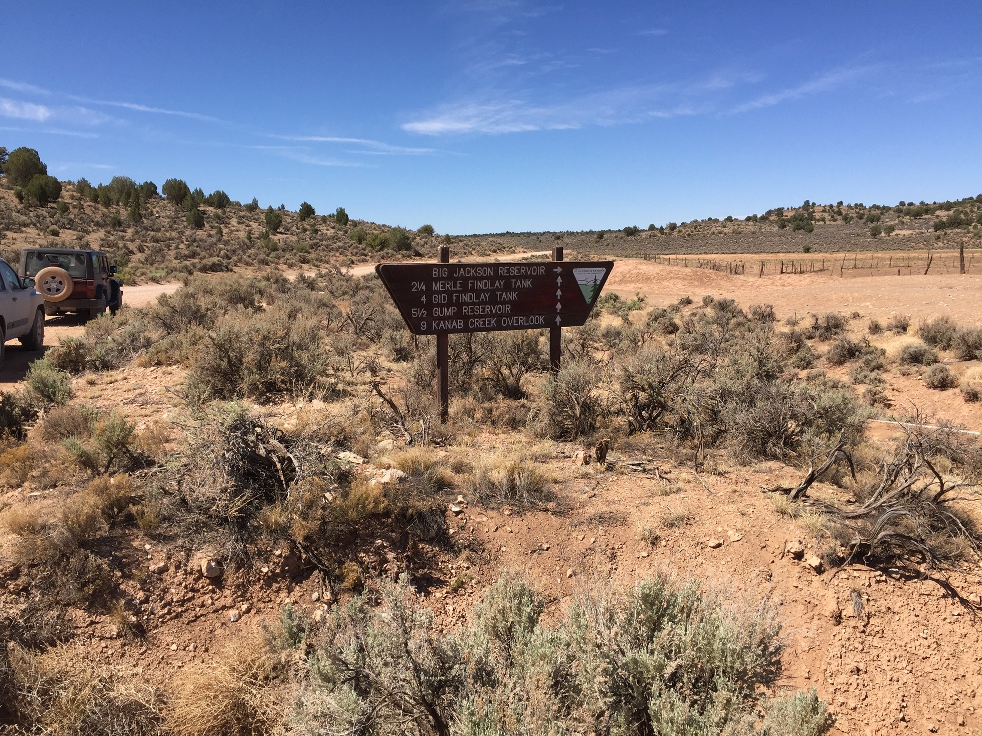 A sign near a corral and water retention pond on the Arizona Strip