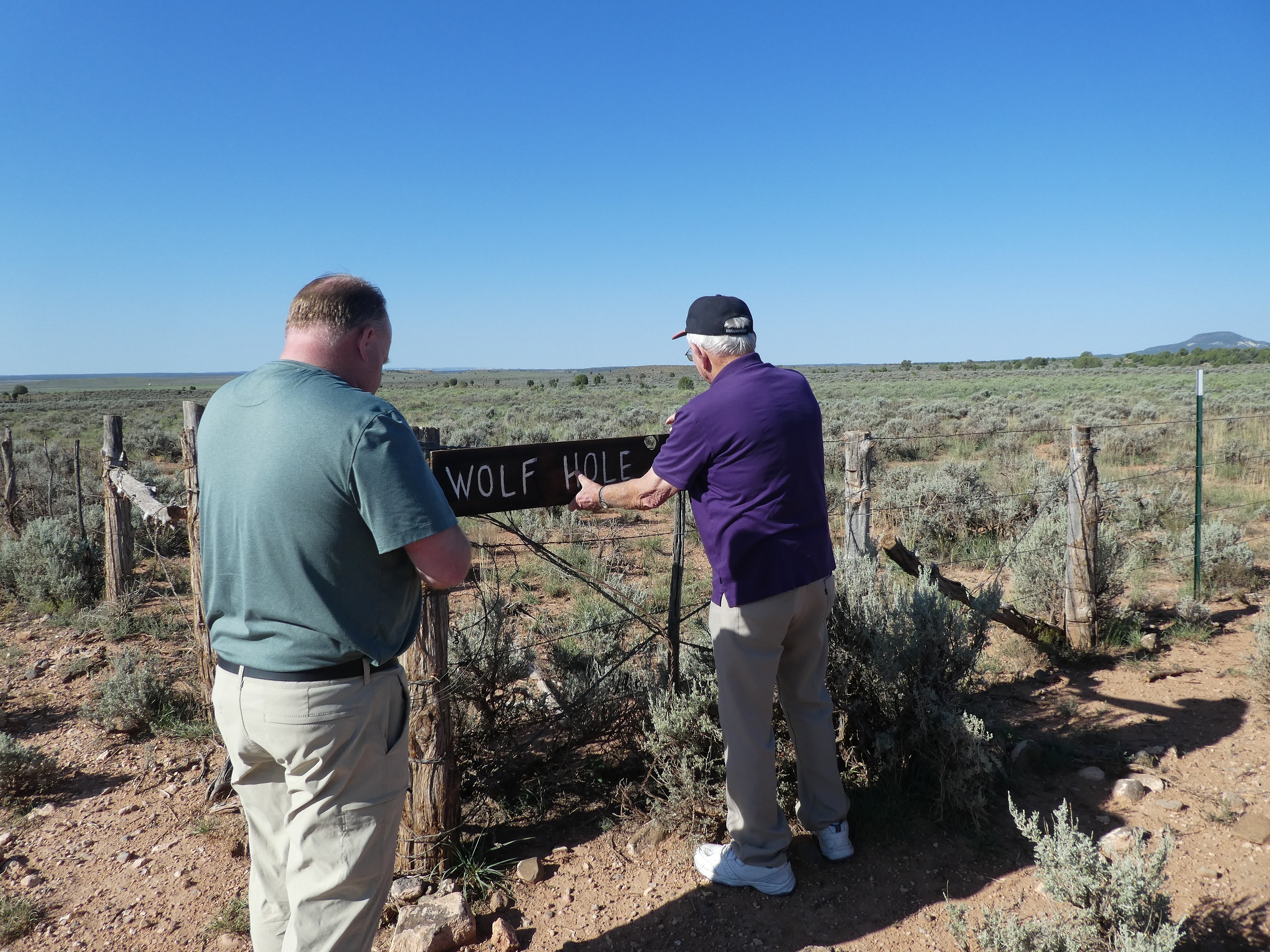 Two men putting up a sign at Wolf Hole on the Arizona Strip