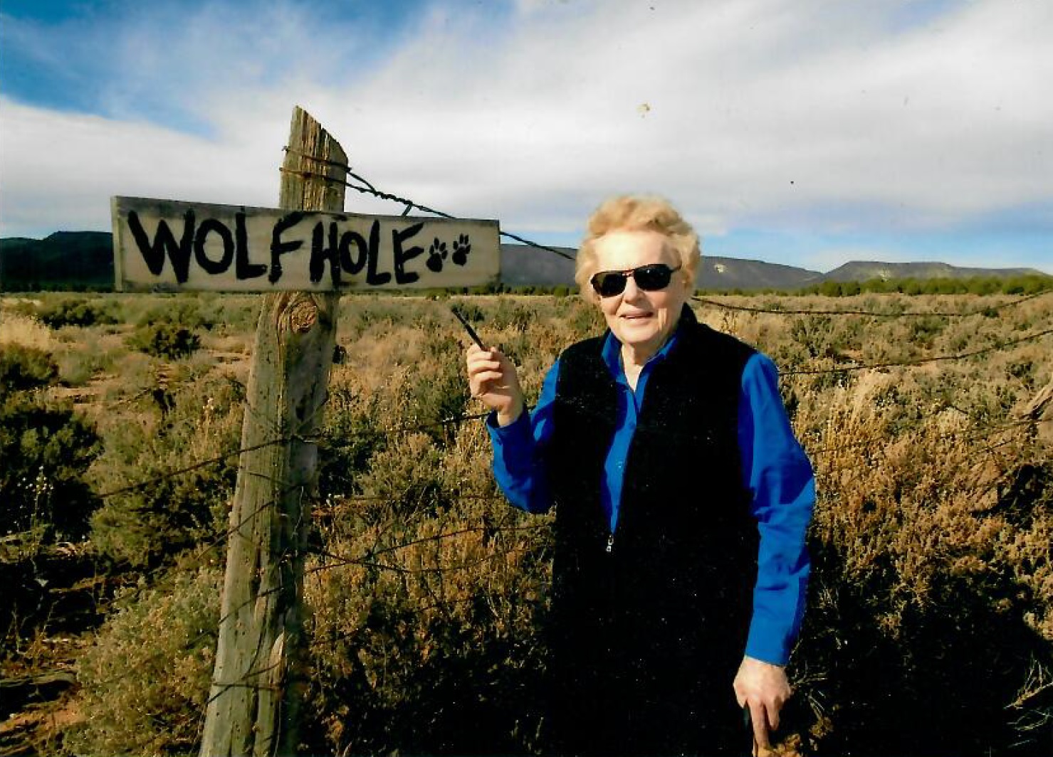 Jean Brown with the Wolf Hole sign she painted