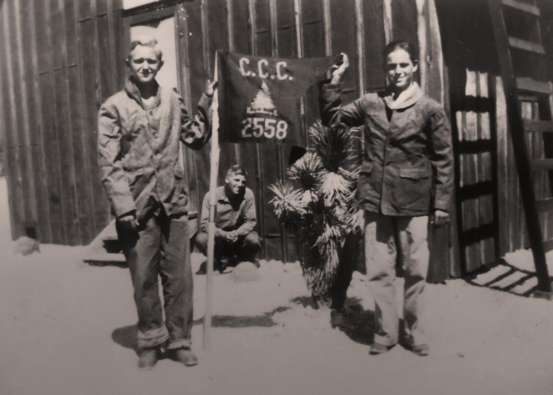 Two enrollees from the St. George CCC Camp holding up a CCC Company 2558 flag