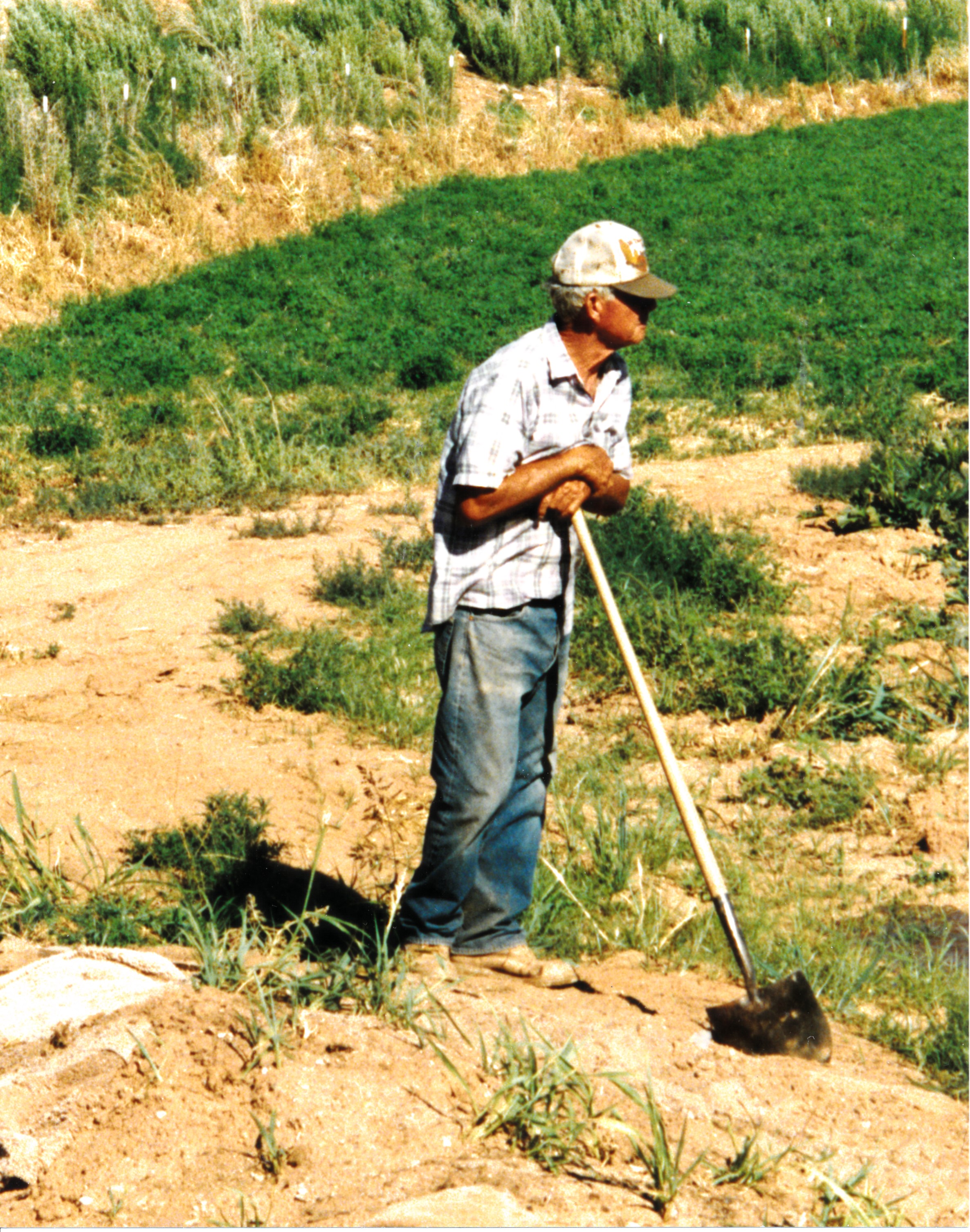Landon Frei standing with a shovel on his farm