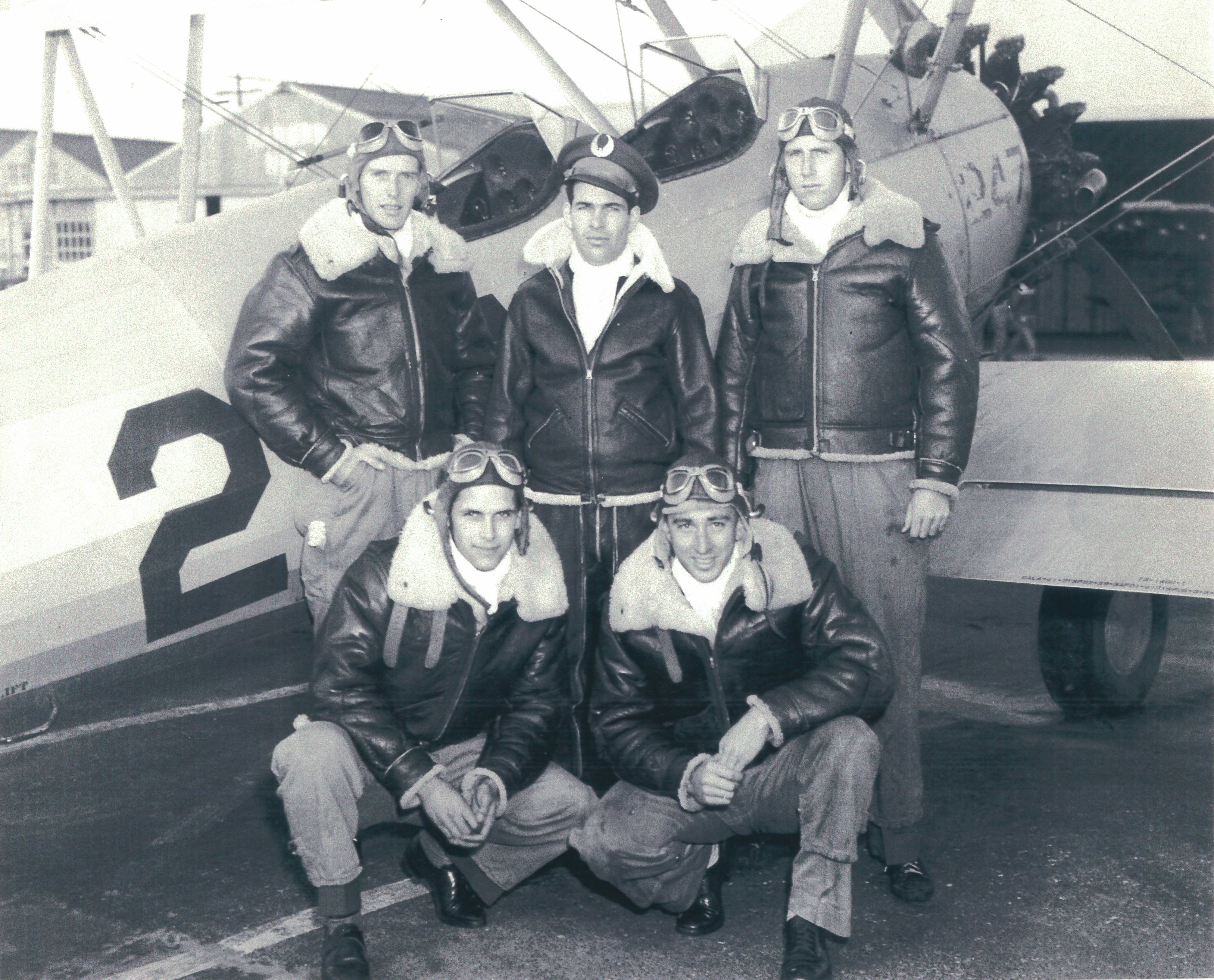 Parke Cox and four comrades in front of an open cockpit airplane